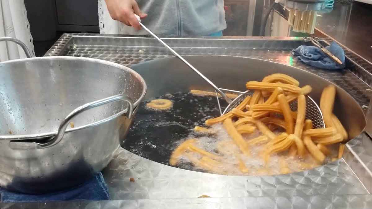 Trabajador de churrería friendo churros donde se descubrió un robo de 86.000 euros al propietario del negocio