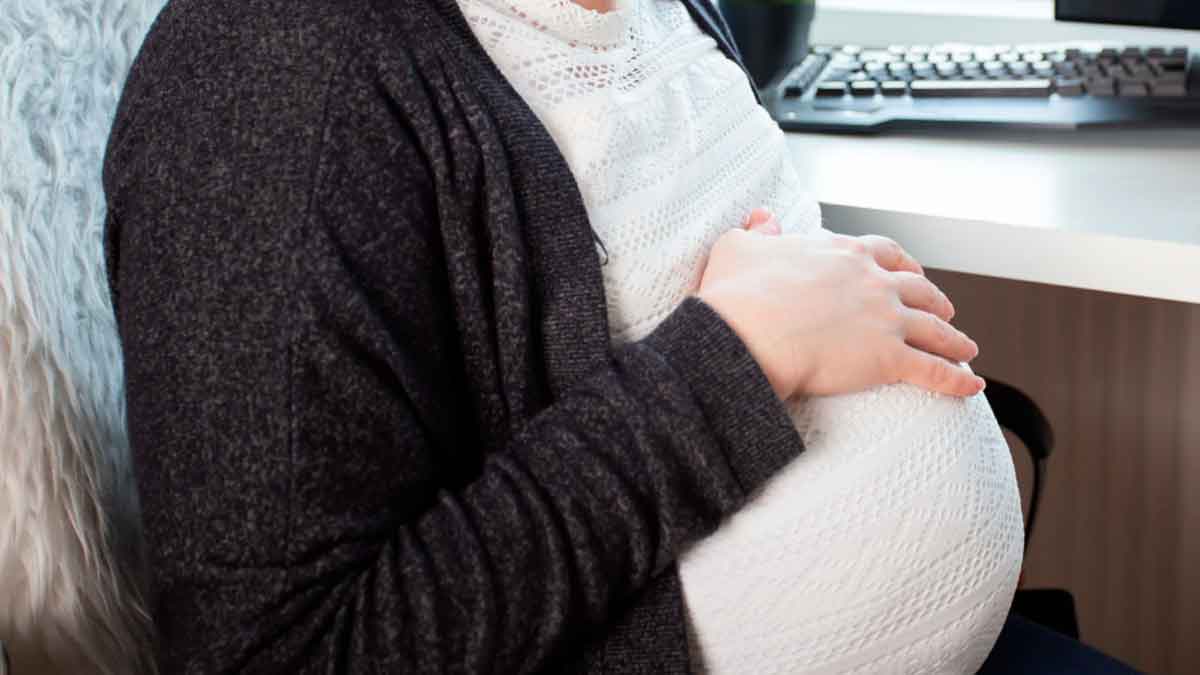 Trabajadora embarazada en su puesto de trabajo antes de ser despedida por usar el móvil y dormirse en horario laboral.