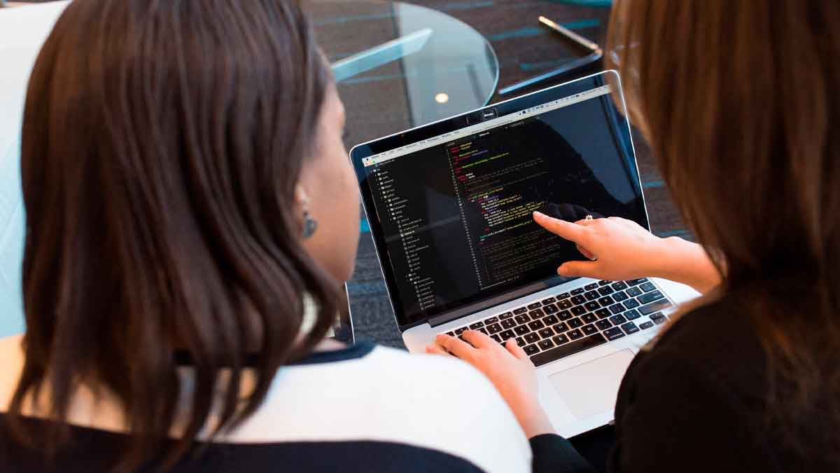 Dos estudiantes de Formación Profesional en informática revisan código en un portátil durante una práctica en Andalucía