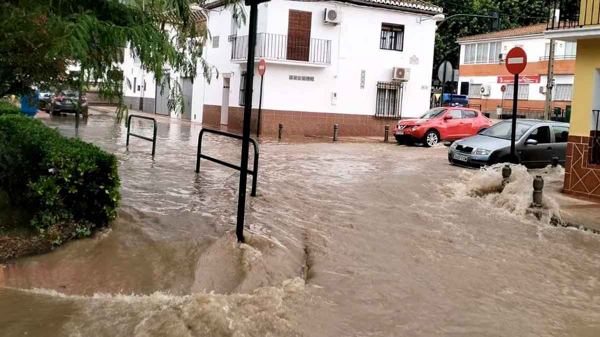 Calle inundada en un municipio de Andalucía durante el aviso rojo por lluvias y la activación del PERI