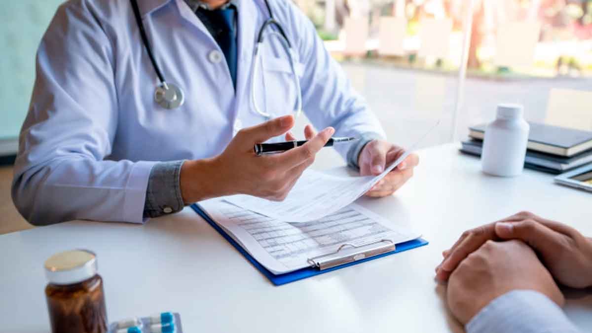 Médico explicando a un paciente cómo cambiar el titular de la asistencia sanitaria según la guía de la Seguridad Social