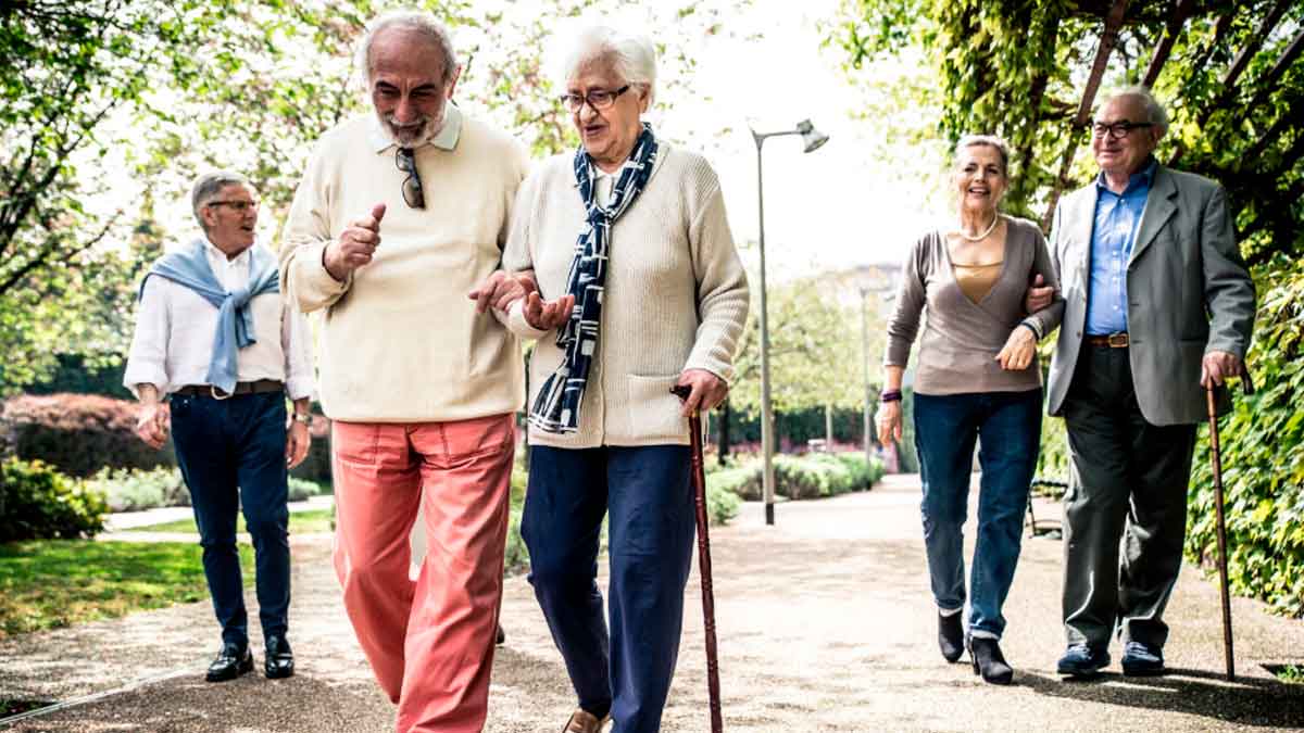 Personas mayores paseando al sol, beneficiadas por el horario de invierno que mejora su descanso y bienestar