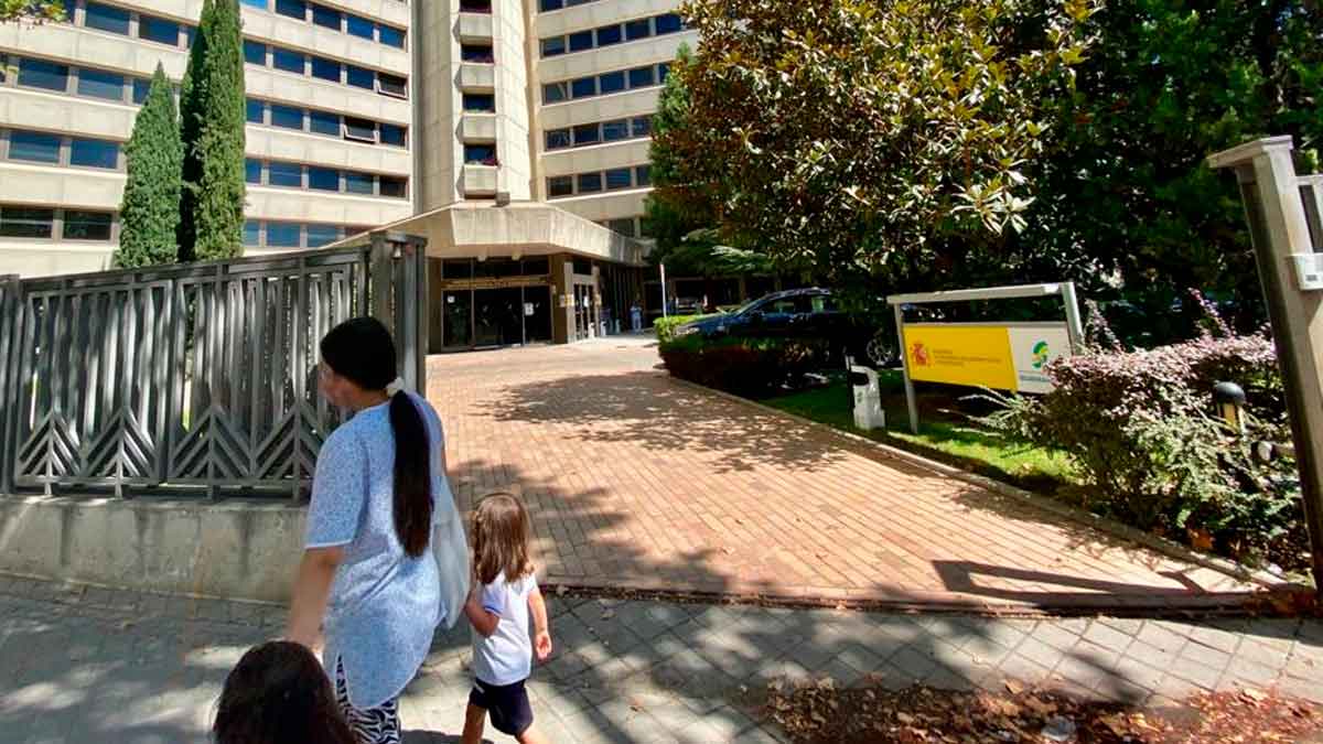 Mujer con hijos frente a una oficina de la Seguridad Social en Andalucía, relacionada con el Ingreso Mínimo Vital del INSS