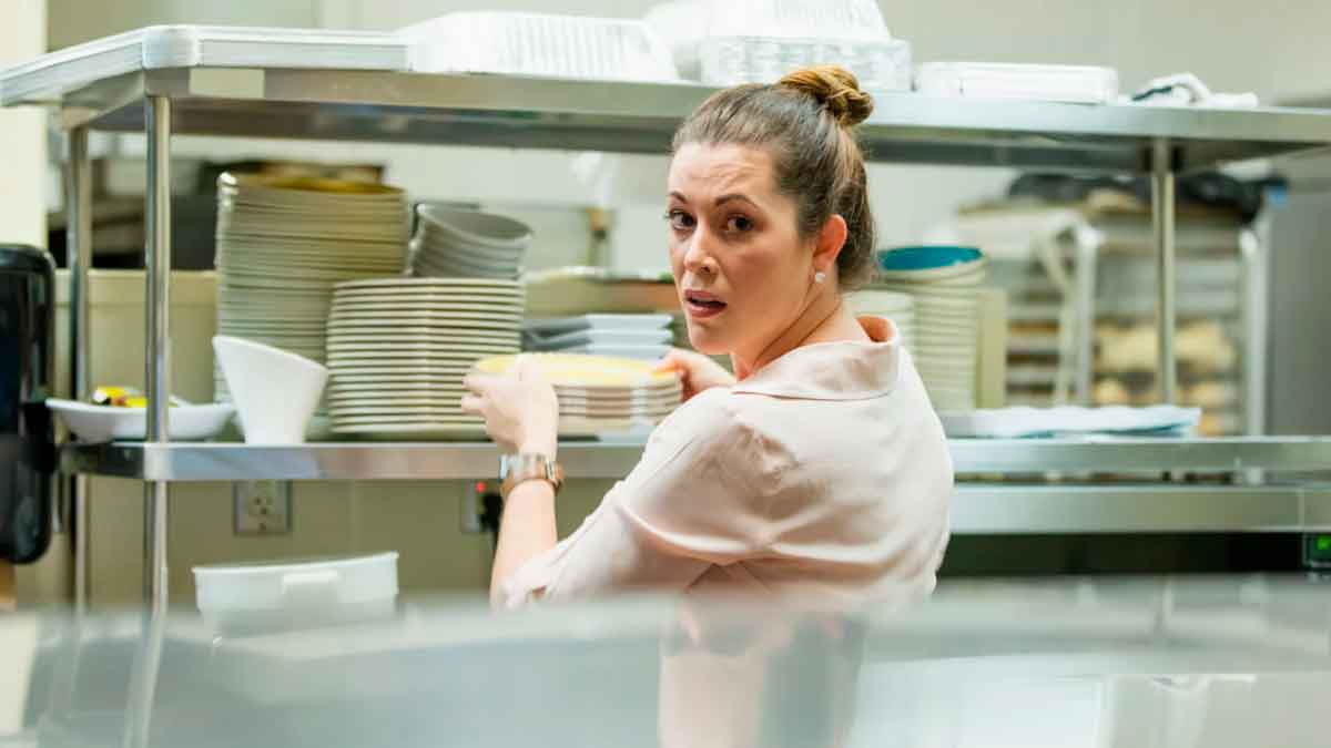 Mujer en el restaurante familiar colocando platos, imagen ilustrativa del caso de despido anulado durante baja médica por ansiedad