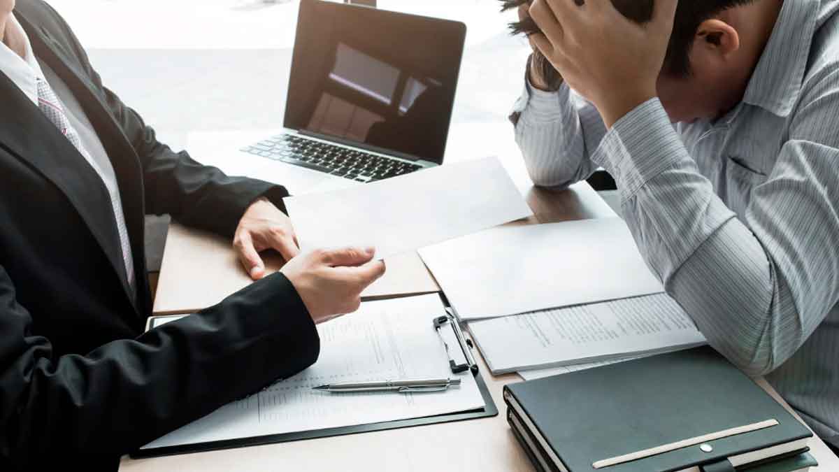 Trabajador recibiendo carta de despido en una oficina mientras gestiona su indemnización por despido improcedente