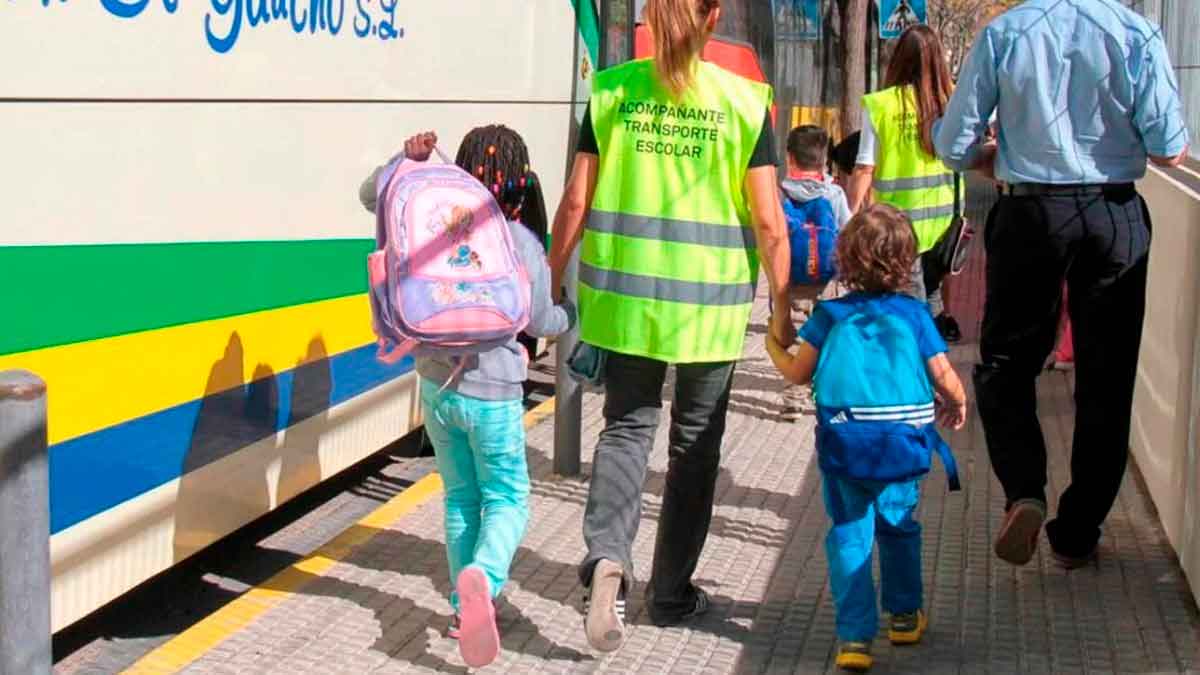 Monitores de transporte escolar acompañando a niños al autobús en Granada durante el curso 25-26