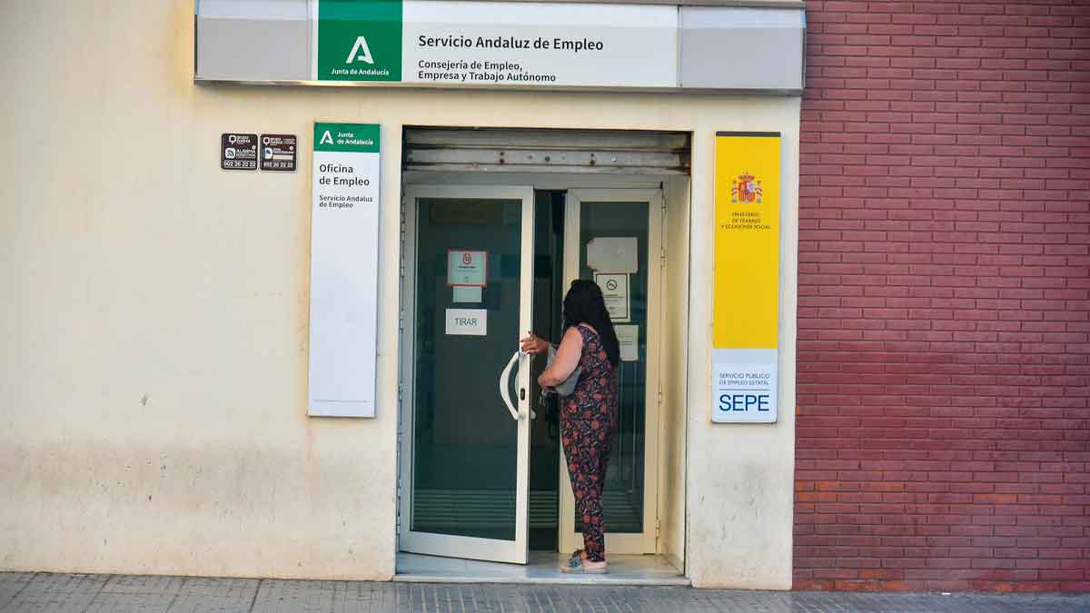 Mujer desempleada mayor de 45 años entrando en oficina SEPE para solicitar subsidio de 570 euros
