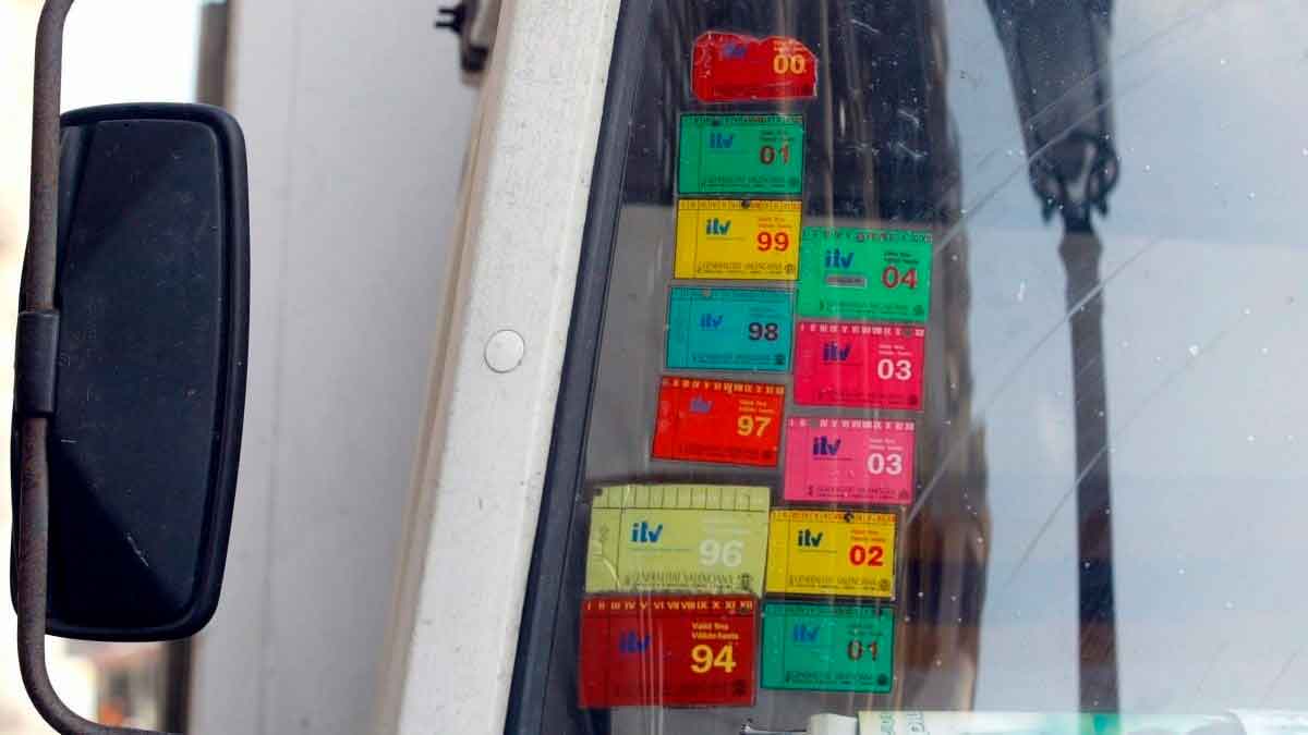 Pegatinas de la ITV mal colocadas en el parabrisas de un coche que pueden provocar multa de la DGT