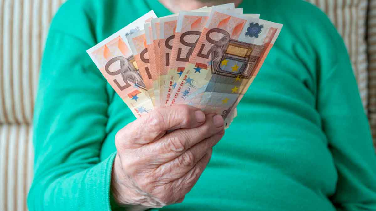 Persona mayor mostrando billetes de 50 euros por pensión no contributiva del IMSERSO en 2025