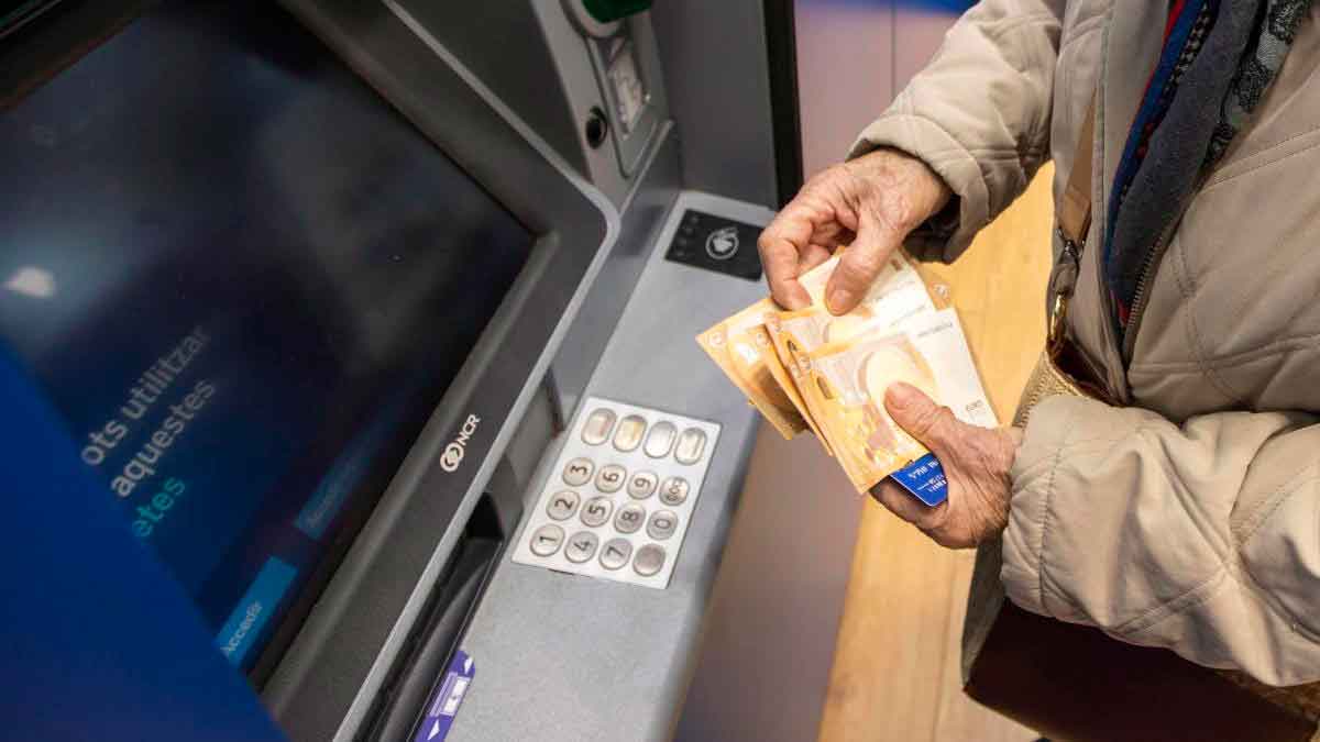 Persona mayor sacando dinero en un cajero automático por la paga extra de Navidad 2025 de los pensionistas