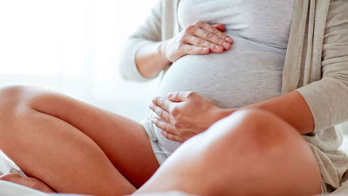 Mujer embarazada sujeta su vientre mientras descansa y tiene derecho a permiso retribuido por riesgo en embarazo