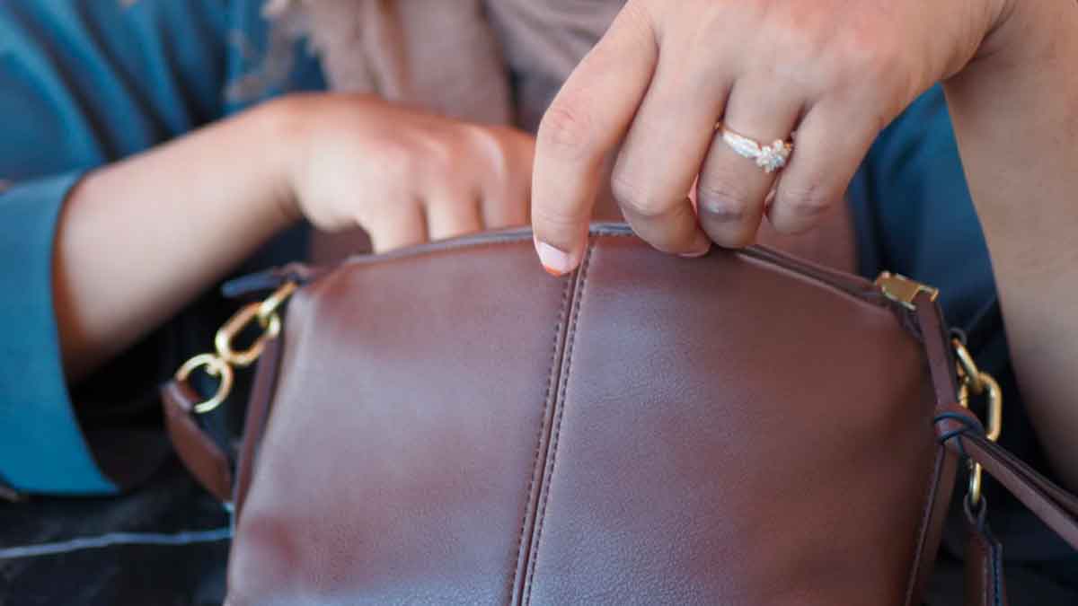Manos de una mujer abriendo un bolso marrón en referencia a una sentencia del Supremo sobre registro ilegal