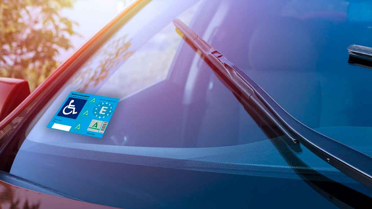Tarjeta de aparcamiento para personas con movilidad reducida colocada en el parabrisas de un coche en Andalucía 2025