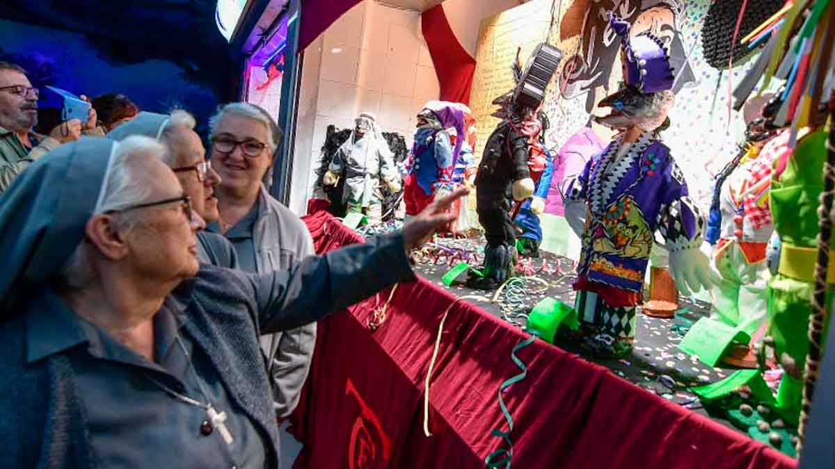 Mujeres observan figuras artesanales durante la celebración de los Tosantos en Cádiz, una tradición del Día de Todos los Santos en Andalucía