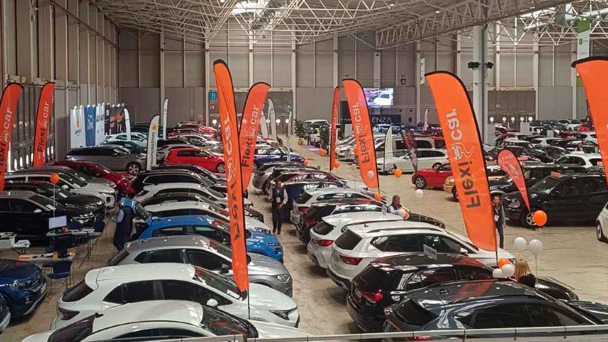 Exposición de coches nuevos y de ocasión en un recinto cubierto, imagen ilustrativa de financiación y préstamos para comprar coche