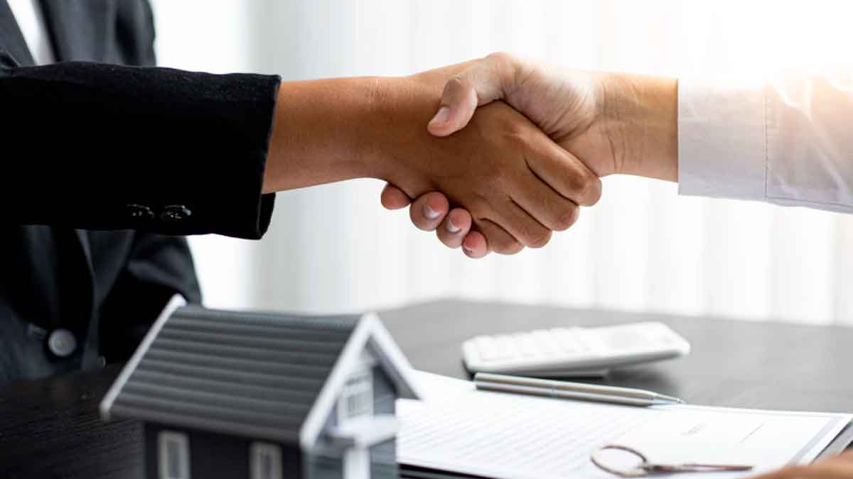 Apretón de manos entre comprador y vendedor tras acordar el pago de los gastos de comunidad en la compraventa de una vivienda