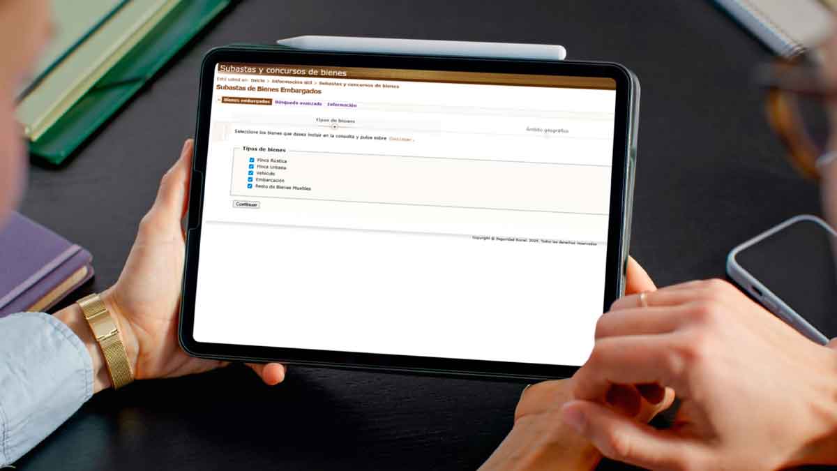 Persona consultando el portal de subastas de bienes embargados de la Seguridad Social para comprar viviendas desde 1.000 euros