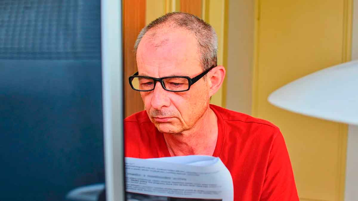 Hombre mayor revisando documentación sobre una ayuda del SEPE antes de la jubilación