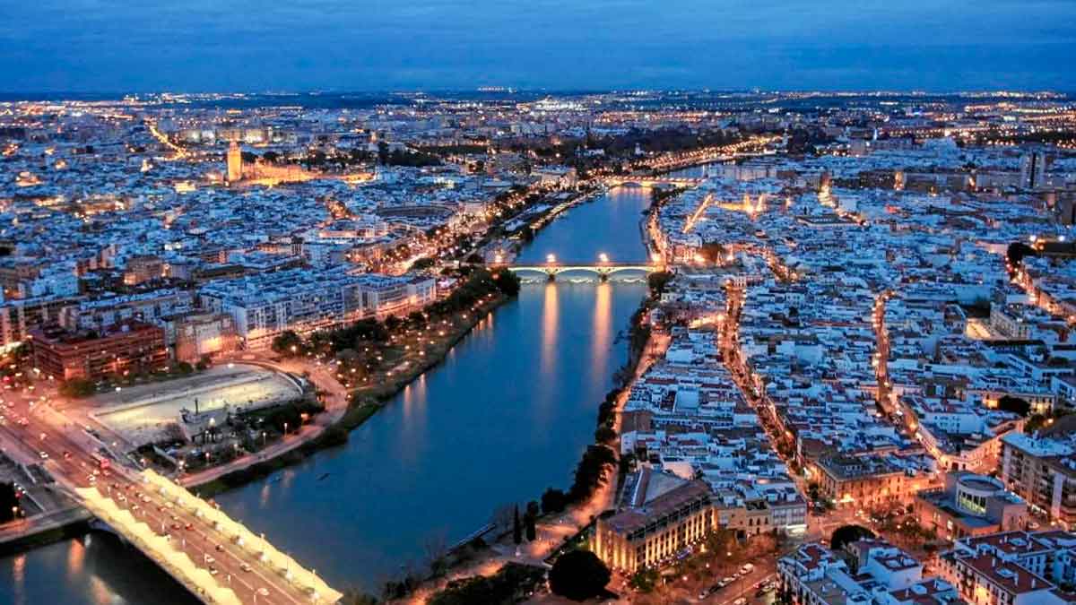 Vista panorámica nocturna de Sevilla, ciudad con los barrios más baratos para vivir en 2025, según Fotocasa Life