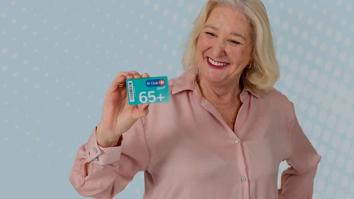 Mujer mayor sostiene la tarjeta +65 de Carrefour para mayores de 65 años con descuentos en productos frescos