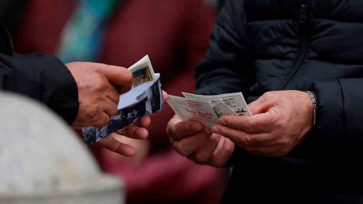 Manos intercambiando décimos de Lotería de Navidad en la calle