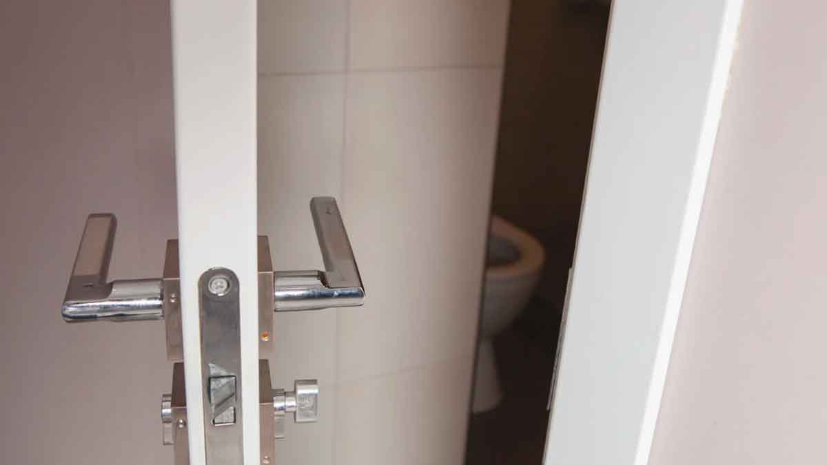 Puerta entreabierta de un baño en una oficina, símbolo del debate laboral por las pausas de los trabajadores