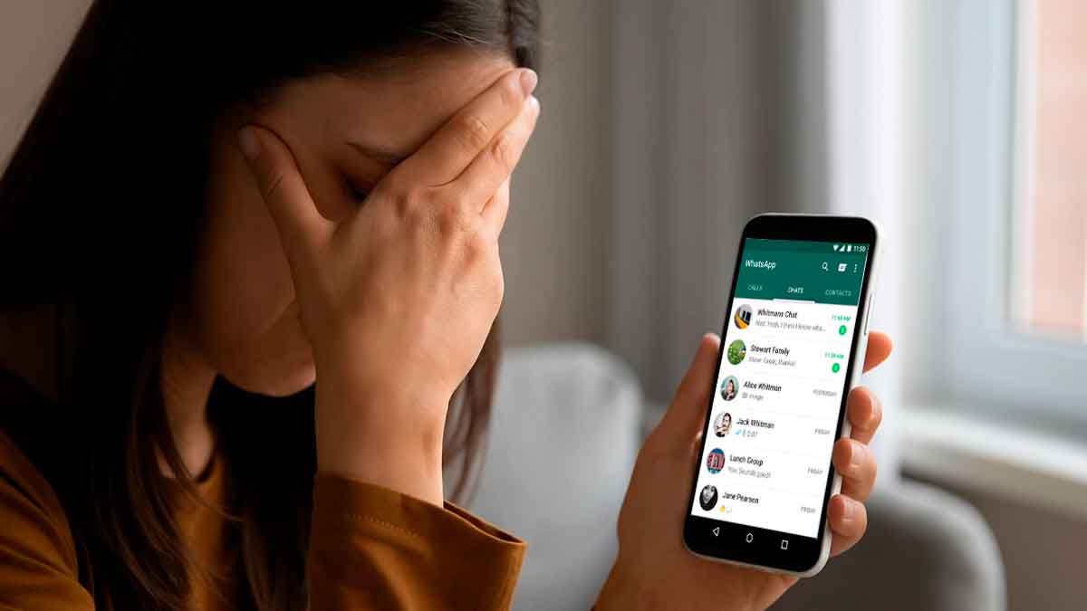 Mujer mirando su teléfono móvil tras ser despedida por WhatsApp durante una baja por depresión, según sentencia judicial