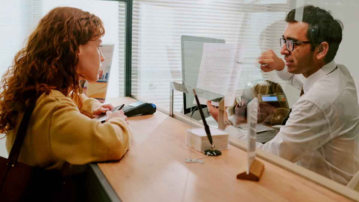 Cliente recibiendo información sobre un préstamo en una oficina bancaria