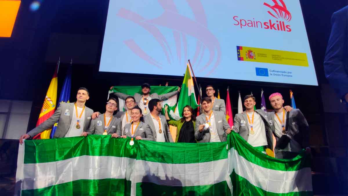 Grupo de estudiantes andaluces celebrando con banderas en la competición SpainSkills