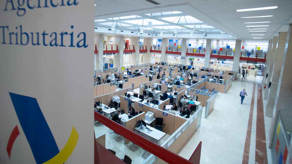 Oficina de la Agencia Tributaria con empleados gestionando trámites y revisiones de la Renta de autónomos