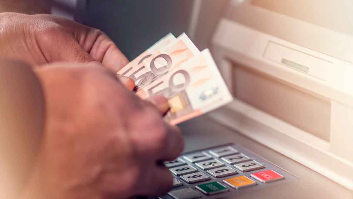 Persona sacando dinero de un cajero automático al cobrar el Ingreso Mínimo Vital en noviembre de 2025