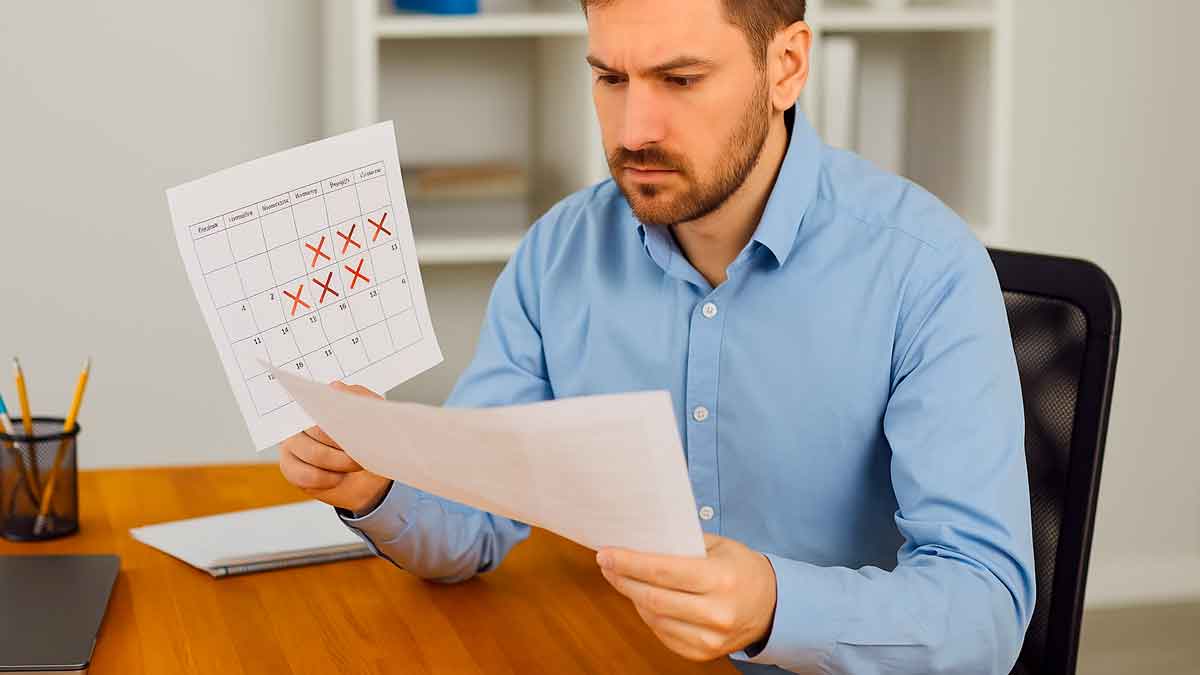 Trabajador revisando un calendario de vacaciones en su oficina ante las sanciones de la Inspección de Trabajo