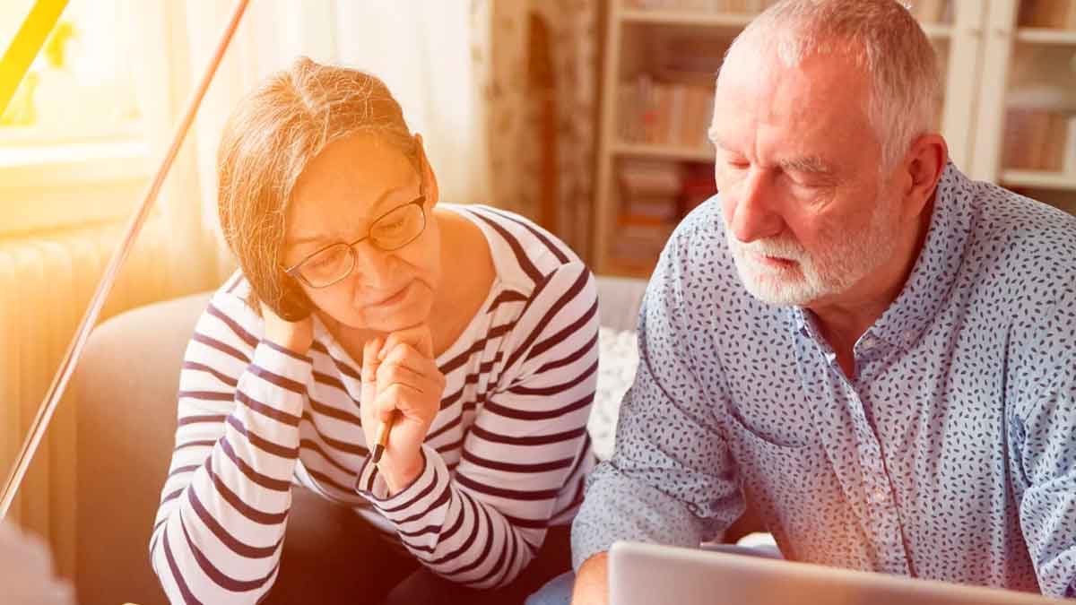 Pareja mayor revisando información sobre jubilación anticipada y penalizaciones en 2025