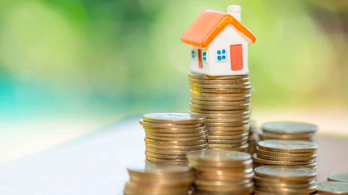 Casa en miniatura sobre monedas que representa el aumento del coste de las hipotecas en España