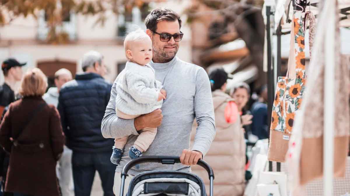 Padre paseando con su bebé en carrito por la calle