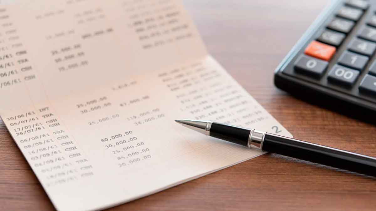 Libreta bancaria con cálculos y bolígrafo sobre escritorio, ilustrando promociones bancarias de noviembre 2025 según la OCU