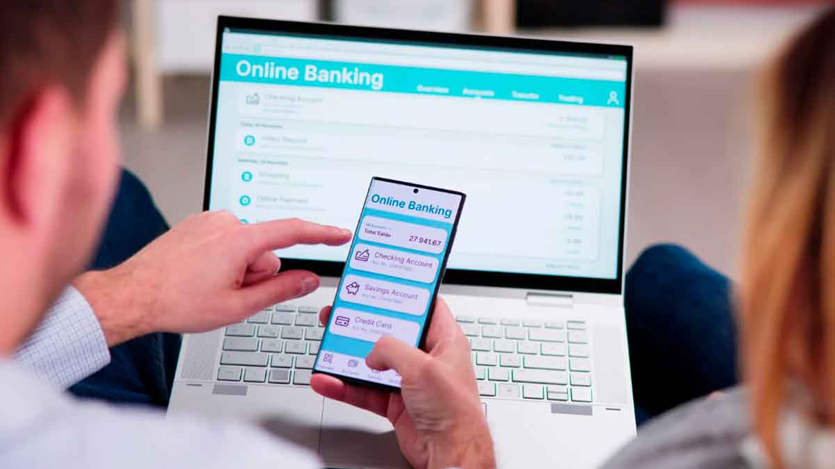 Persona revisando su banca online en móvil y ordenador para comprobar movimientos y detectar posibles cargos indebidos