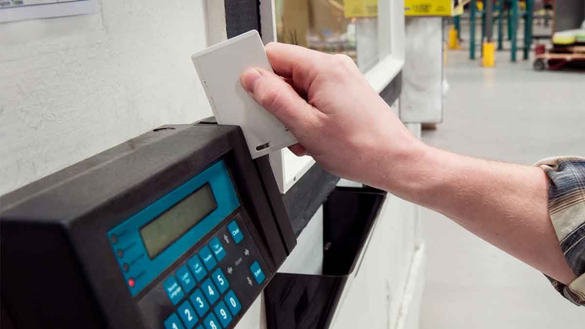 Persona fichando con tarjeta en un sistema de registro horario digital en su empresa