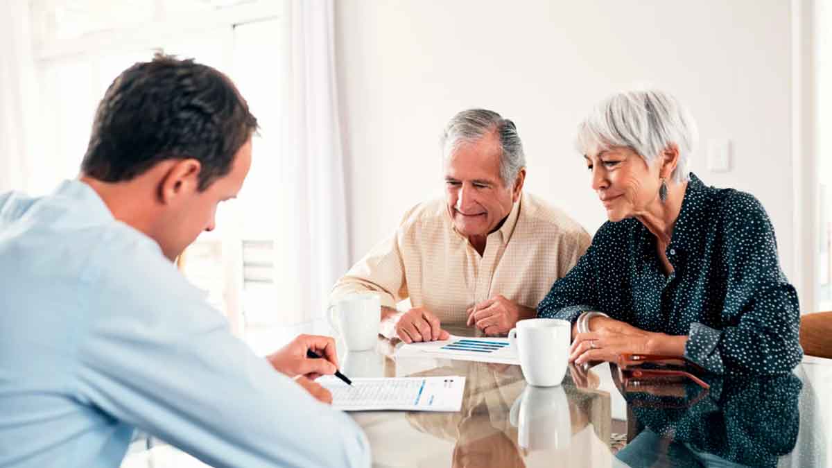 Pareja de jubilados recibiendo asesoramiento para rescatar su plan de pensiones
