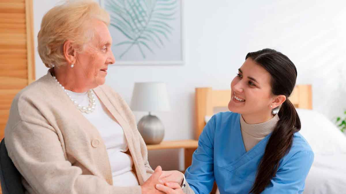 Auxiliar de ayuda a domicilio atendiendo a una persona mayor en su hogar en Andalucía