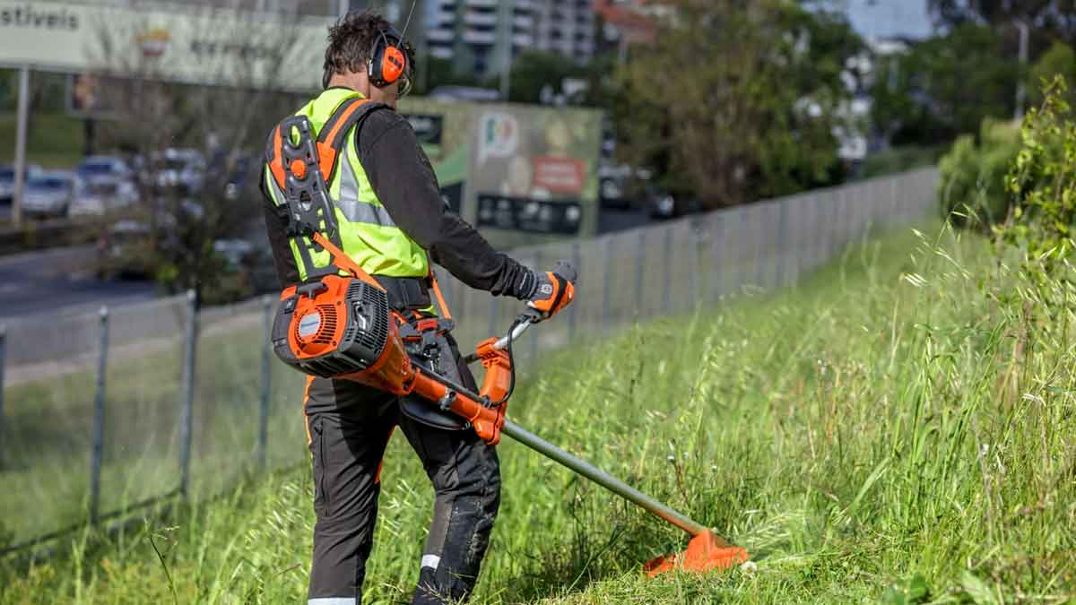 Trabajador de jardinería desbrozando una zona verde en Andalucía con equipo profesional