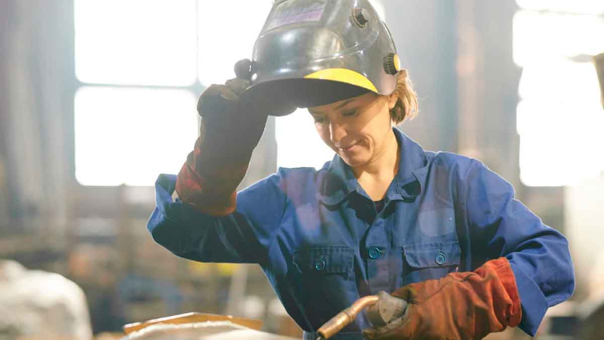 Soldadora realizando trabajo de soldadura TIG en taller industrial
