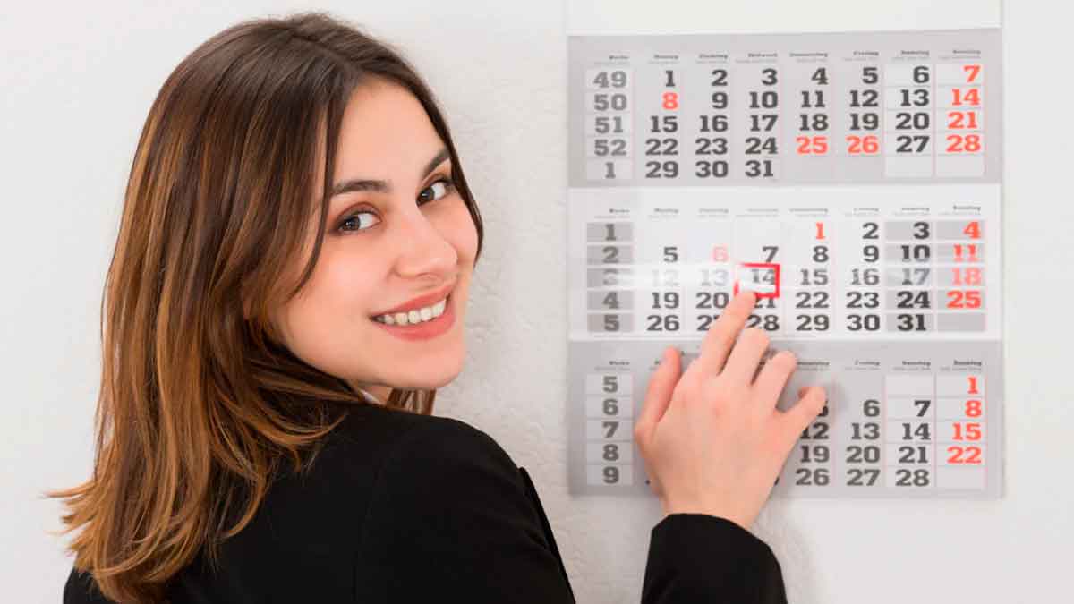 Mujer señalando un calendario mientras revisa sus días de vacaciones laborales