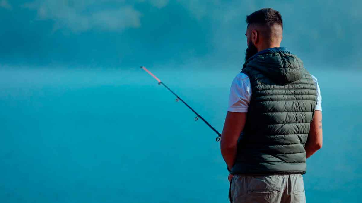 Trabajador pescando en la playa durante una baja médica laboral