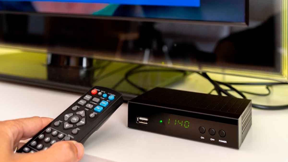 Decodificador de TDT y mando a distancia frente a un televisor