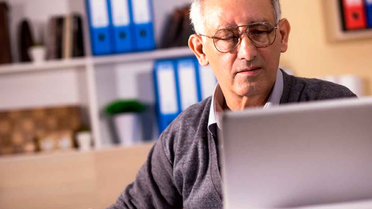 Trabajador mayor consultando información sobre la jubilación en 2026 frente al retraso de la Seguridad Social