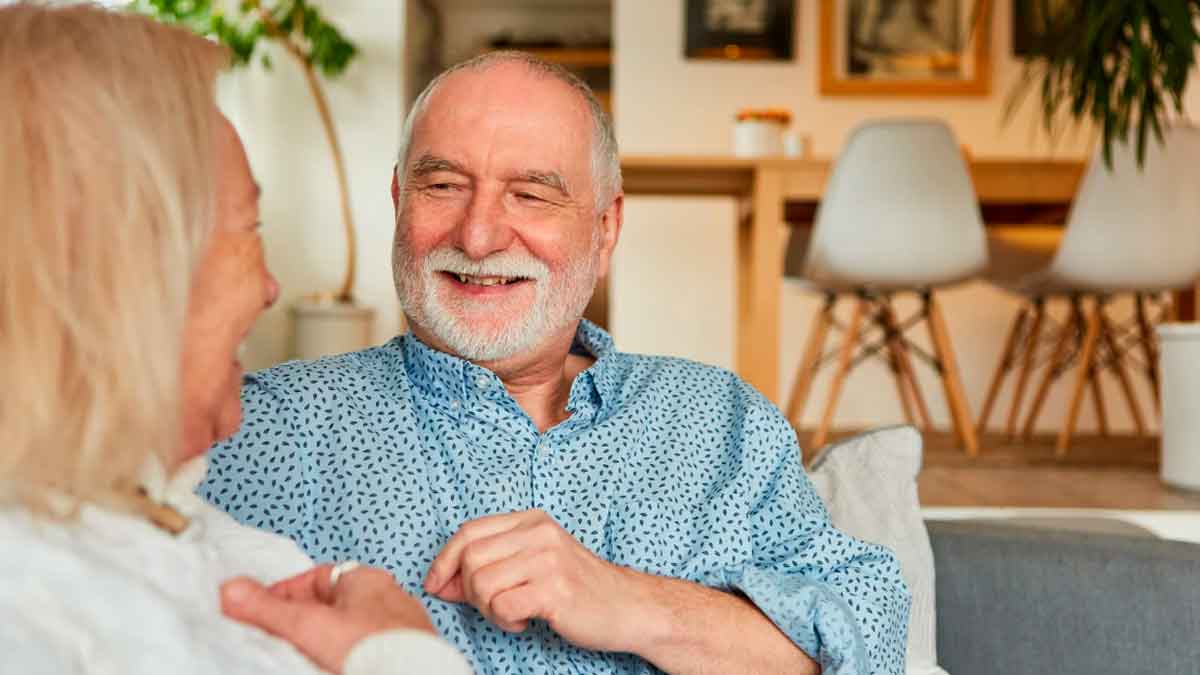 Pareja de pensionistas conversando en casa tras conocer la subida de las pensiones prevista para 2026