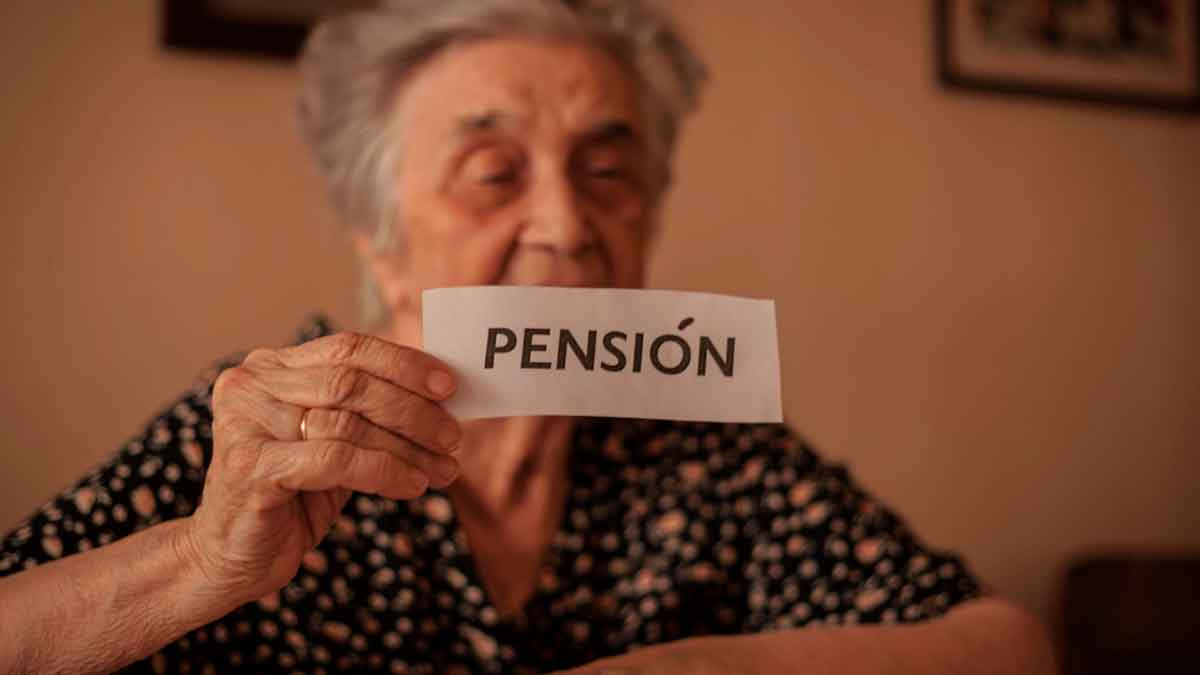 Persona mayor sosteniendo un cartel con la palabra pensión