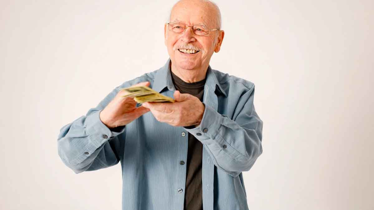 Hombre jubilado sonriente contando dinero relacionado con la pensión por menos de 15 años cotizados en 2025