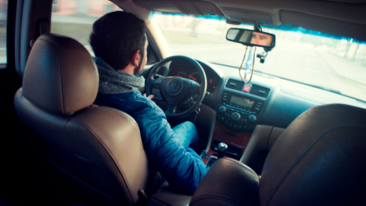 Joven conduciendo un coche tras obtener la ayuda de 200 euros para el carnet de conducir